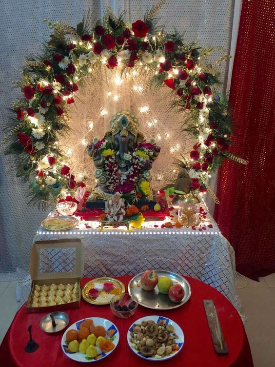 Brown Ganesha with decorated round floweral garland and serial lights