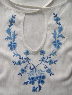 12. White top with dark and light blue embroidery design