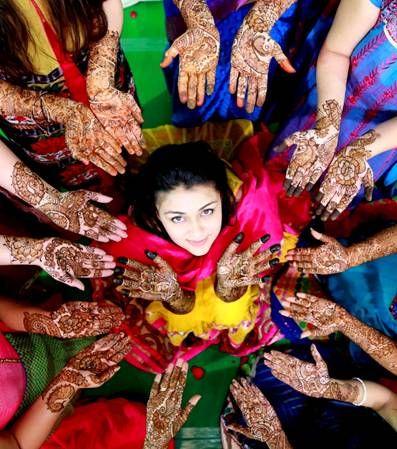 Bride rounded by girls with mehndhi